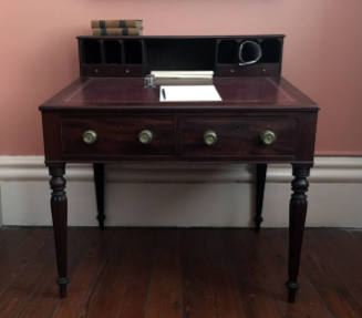 A mahogany writing desk with a slanted fold over top lined in red leather, seven open-air compa…