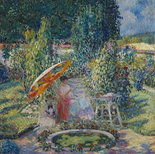 A view of a garden with a small pool in the foreground with two women seated just behind it, on…