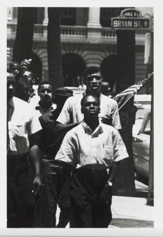 A group of African American males walking in Savannah at the corner of Bull Street and W. Bryan…