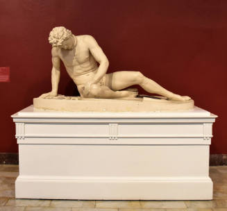A wounded, enslaved nude male reclining on a shield next to a sword and trumpet.