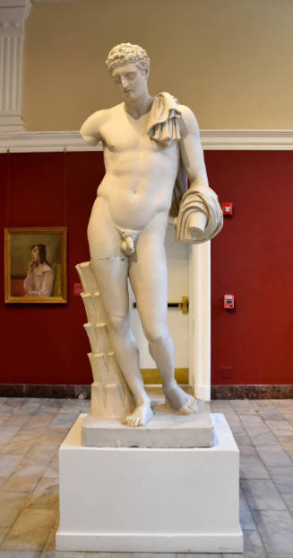 A standing nude male with fabric draped over his left shoulder and curled around his arm.