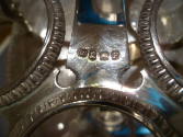 An image of the maker's marks on the bottom of the silver cruet stand. 