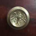 A detail of one of the brass drawer pulls with the Great Seal of the United States of America f…