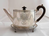 The reverse of the silver teapot adorned with bright-cut garlands, cartouches, beading and a wo…