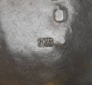 A detail of the stamped maker's mark on the interior of the teapot. 