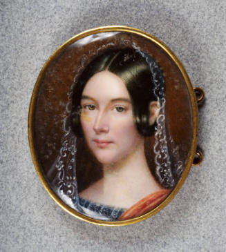 A miniature watercolor in a simple, gold oval frame. A portrait of a fair-skinned woman with he…