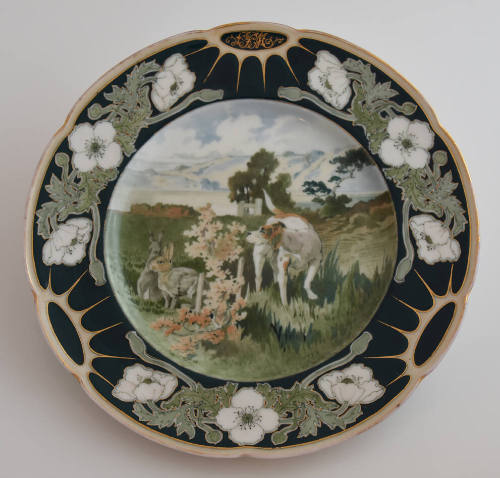 The first plate features a blue rim with three clusters of white flowers and green leaves alter…