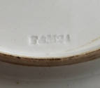 A detail of the maker's mark impressed on the bottom of the tenth plate in the set. This partic…