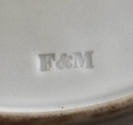 A detail of the maker's mark impressed on the bottom of the twelfth plate in the set. This part…