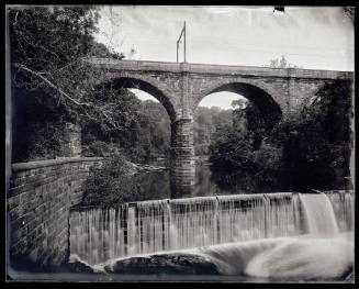 A bridge crosses over the Schuylkill River and a small waterfall.