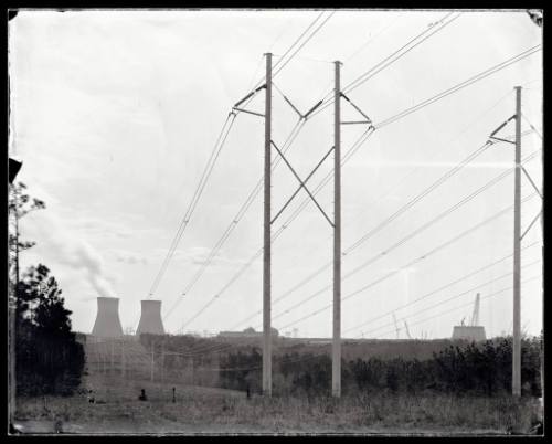 Powerlines recede to a powerplant in the background.
