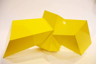 A cubic sculpture painted bright yellow.