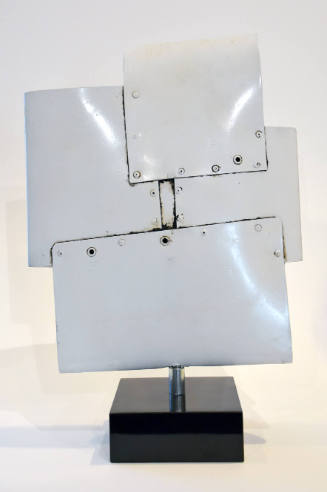 A white, metallic sculpture, roughly square in shape, composed of overlapping square metal shee…