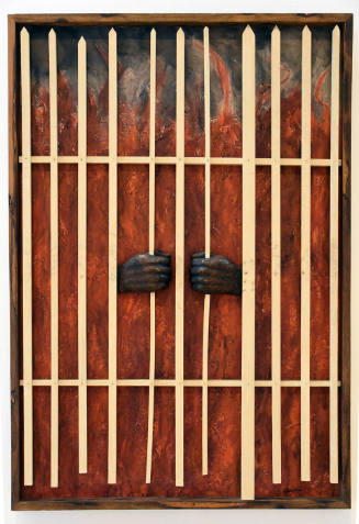 A pair of brown wooden hands emerge from flames to clasp the bars of a white fence.