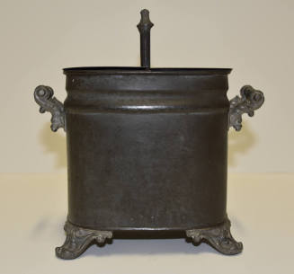 A tin egg coddler with cast legs and handles.
