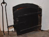 The front of the bottom oven door door with curved wrought iron handle. 