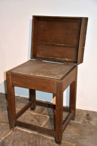 A four-legged square table with thick open lid and marble top.