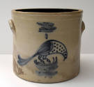 A cream-colored crock painted with a blue bird on the side.