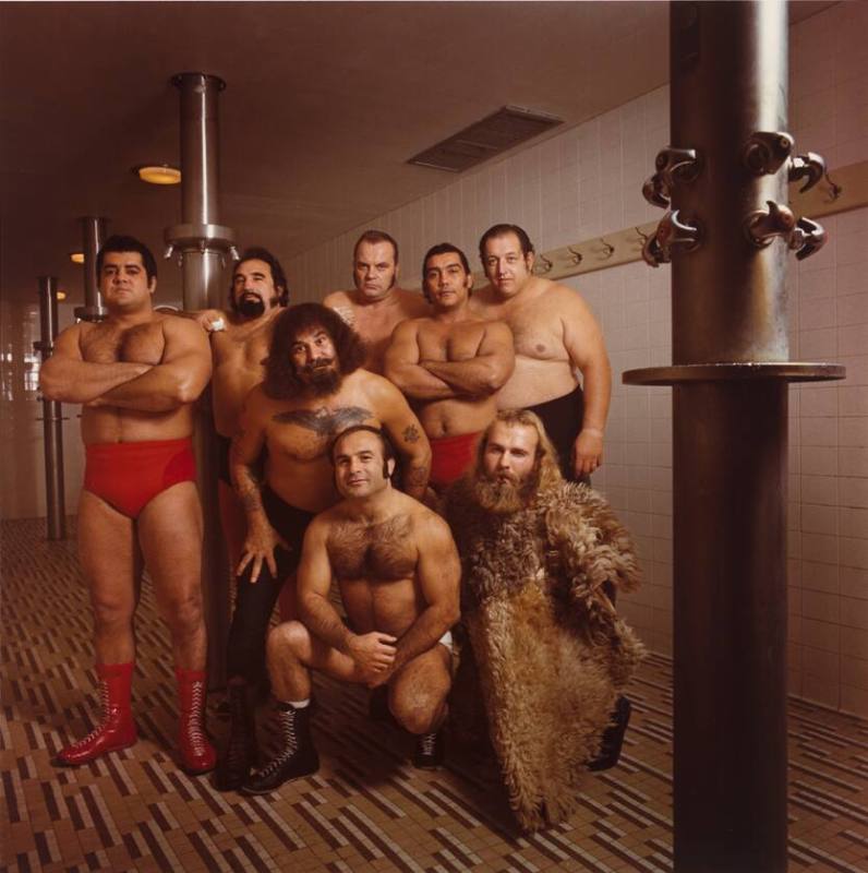 A group of wrestlers standing in a shower.