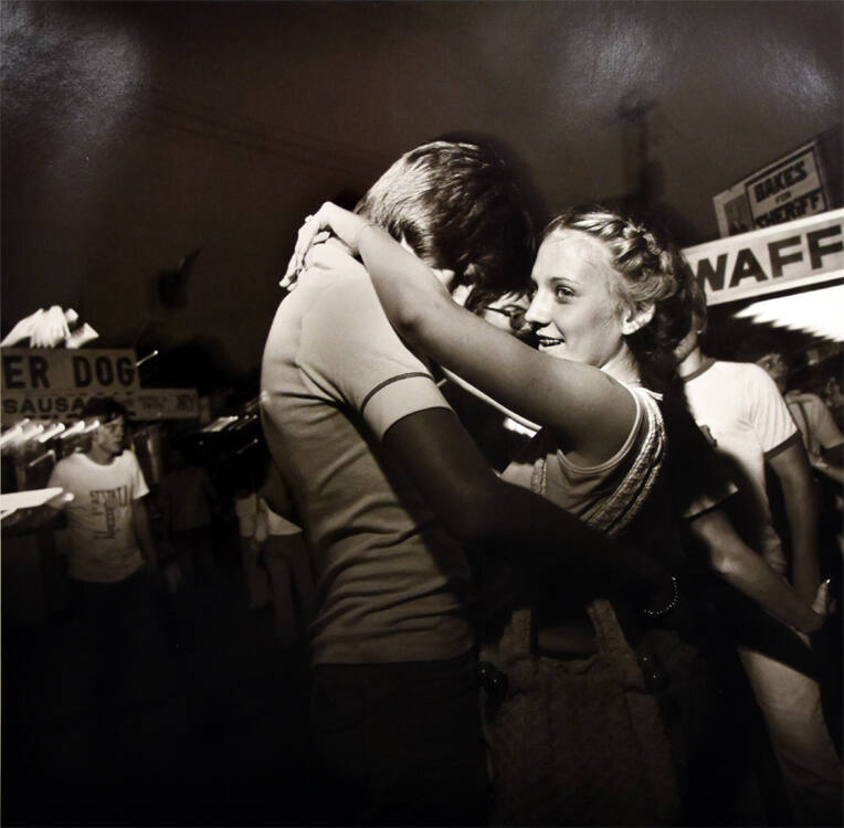 A black and white photograph of a teen couple dancing.
