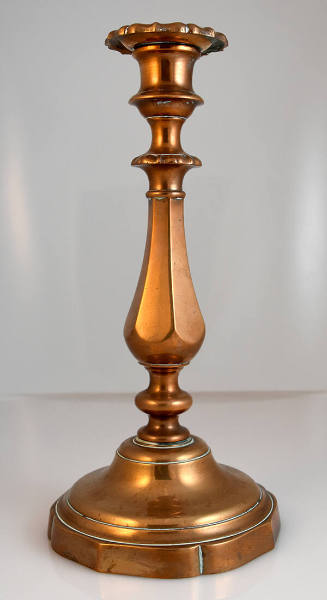 One of a pair of copper candlesticks with detached bobeches, and round, fluted bases.