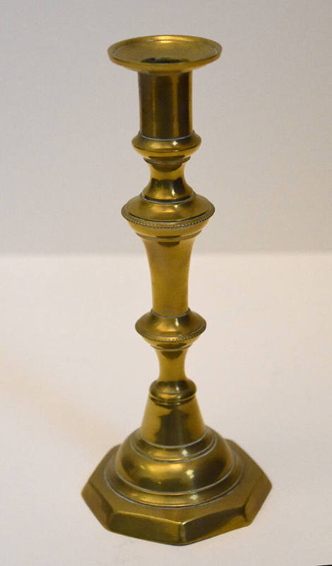 One of a pair of brass candlesticks with an octagonal base.