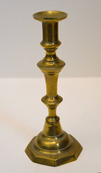 One of a pair of brass candlesticks with an octagonal base.
