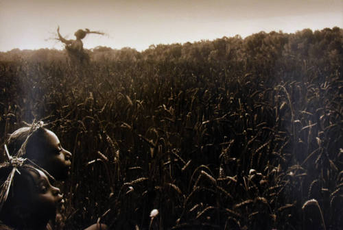 Two women in the bottom left corner and a third in the background, all wearing wheat headdresse…