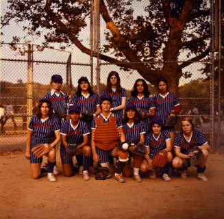 A women's softball team wearing blue striped uniforms and staged in two rows. 