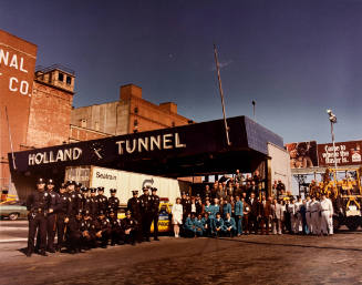 A group of transportation workers standing underneath a sign that says "Hollland Tunnel."