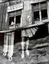 A black and white photograph of a billboard depicting a pair of male and female legs on the sid…