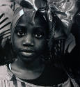 A black and white photograph of a girl with a metallic head wrap and an off-the-shoulder stripe…