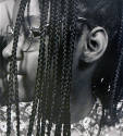 A black and white photograph of the profile of a girl with glasses and many braids looking back…