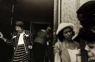 A black and white photograph of a woman in a striped suit exiting a church.