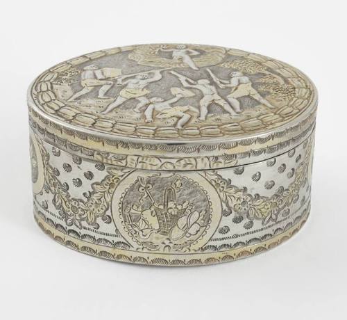 An oval gilded sterling silver box with mythological repousse decorations.