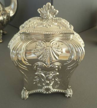 An English sterling silver tea caddy with hinged lid in a Georgian bombe-form embossed with fol…