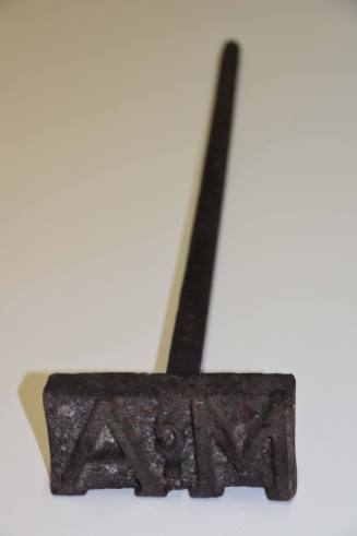 A branding iron with a rectangular head and wooden grip on the rod. 