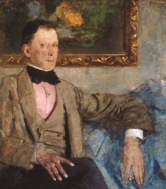 Three-quarter length portrait of a man seated on a blue sofa with his legs crossed, looking out…