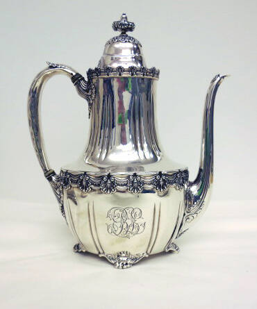 A sterling silver coffeepot with four clawed-feet and floral gadrooning around the waist and ed…