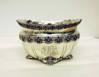 A sterling silver waste bowl with four clawed-feet and floral gadrooning around the waist and r…