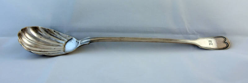 A fiddle patterned serving spoon with a scalloped bowl.