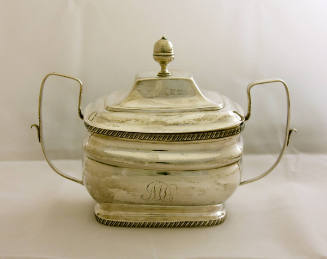A two-handled sugar bowl with a gadrooned footed base, gadrooned rim and accompanied by a remov…