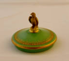 The ornamented lid adorned with a bird of prey finial. 
