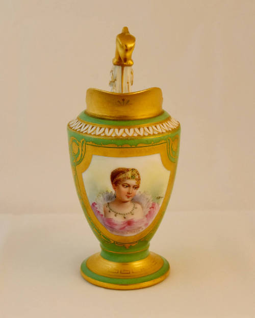 A green porcelain cream pitcher with a gold framed portrait of a noble woman on the body, a gol…