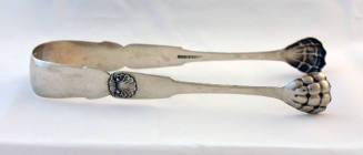 A pair of silver sugar tongs with a shell relief on each shoulder and lion's paw grips. 