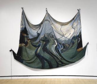 A large-scaled draped tapestry with an image of men lined up against a chain link fence surroun…