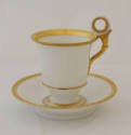 Cup and saucer in white with gold trim. 
