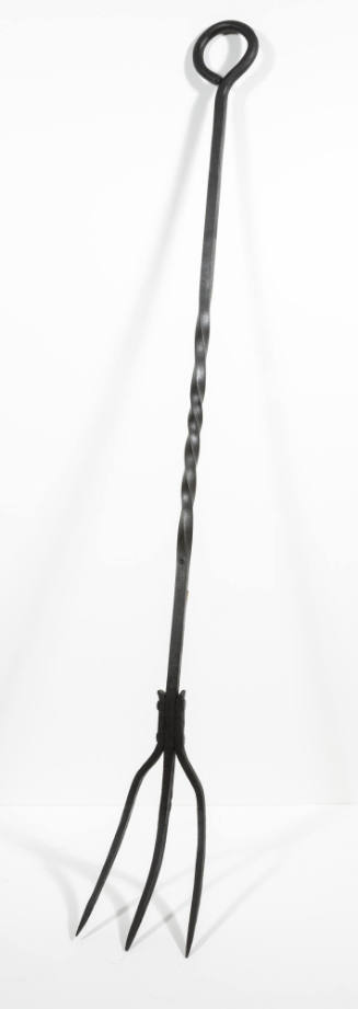 A wrought iron three-pronged fork with a long-twisted handle looped on the opposite end for han…