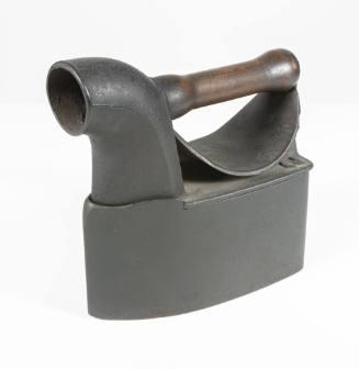 A flat iron with a hollow base for charcoal, a large circular spout for steam and a detachable …