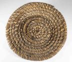 A rice fanner basket made from native wire grass and reeds in a spiral pattern.